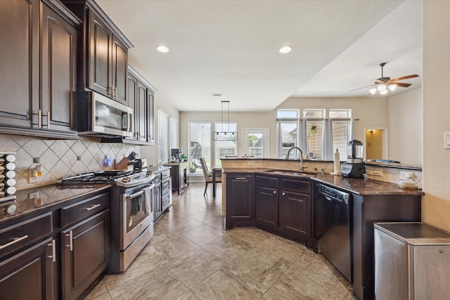 13921 Pebble Falls Ln, Pearland, TX 77584 - kitchen featuring appliances with stainless steel finishes, a sink, backsplash, dark brown cabinetry, and recessed lighting