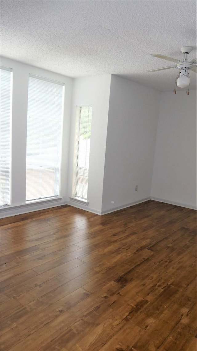 unfurnished room with a ceiling fan, baseboards, a textured ceiling, and wood finished floors