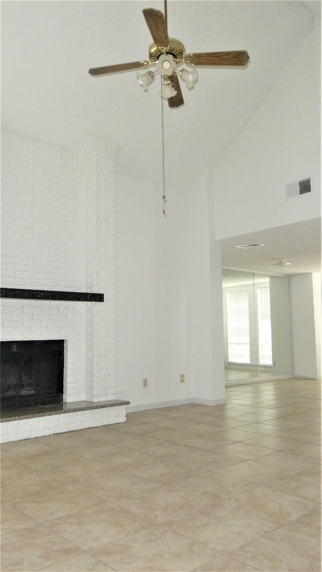 unfurnished living room featuring a fireplace, a ceiling fan, high vaulted ceiling, and visible vents