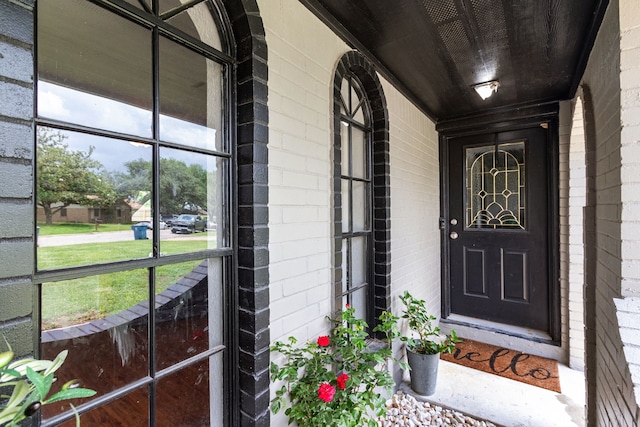 entrance to property with brick siding and covered porch