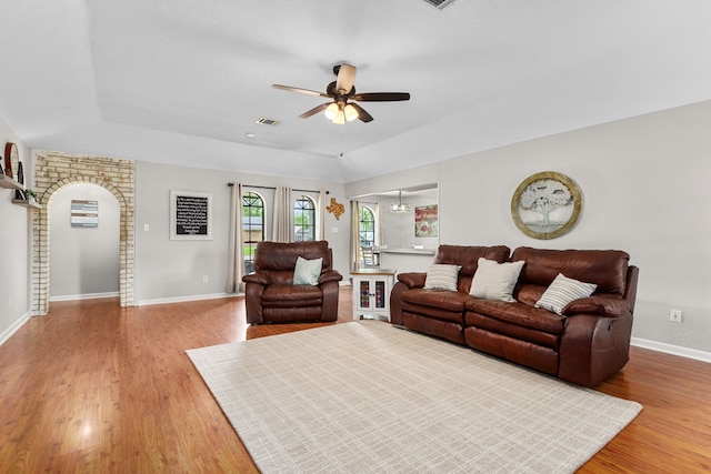 living area featuring a ceiling fan, baseboards, visible vents, and light wood-type flooring