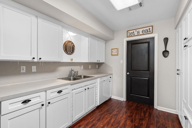 kitchen with baseboards, light countertops, a sink, and dishwasher