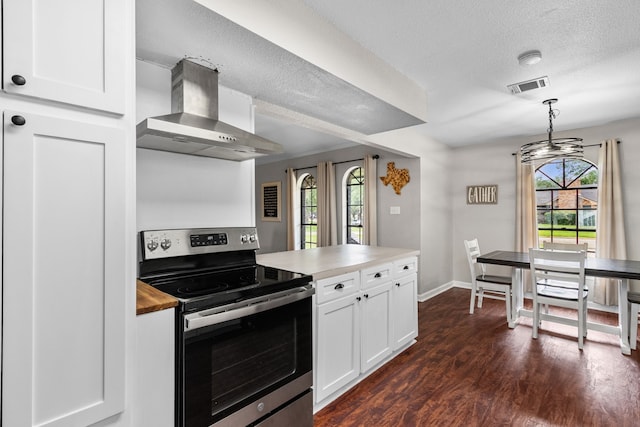 kitchen with wall chimney range hood, a healthy amount of sunlight, visible vents, and stainless steel electric stove