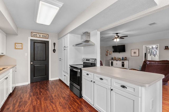 kitchen with a peninsula, light countertops, wall chimney exhaust hood, and stainless steel electric range