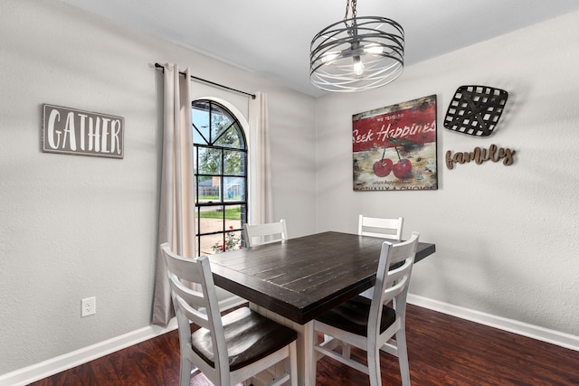 dining room with a chandelier, baseboards, and wood finished floors