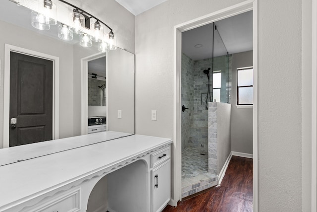 full bathroom featuring baseboards, tiled shower, and wood finished floors