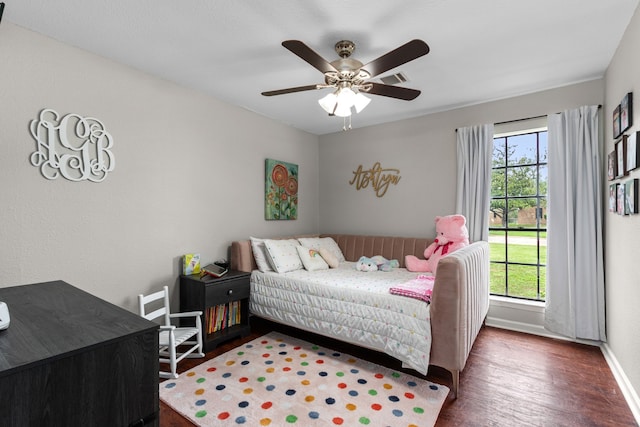 bedroom with visible vents, wood finished floors, baseboards, and ceiling fan