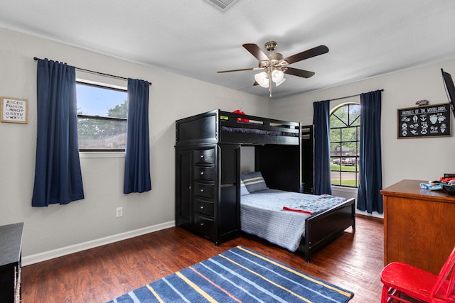 bedroom with baseboards, a ceiling fan, visible vents, and wood finished floors