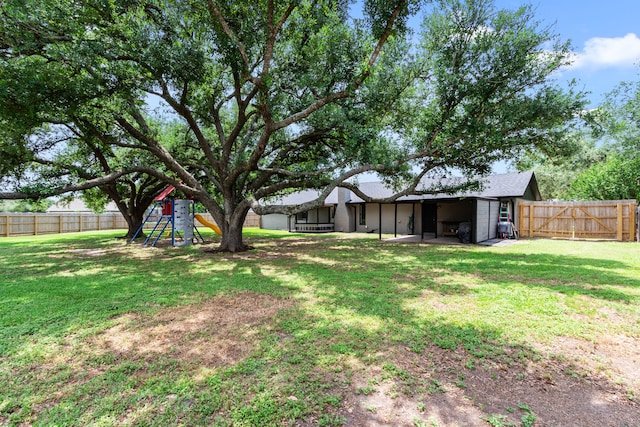 view of yard with a fenced backyard and a playground