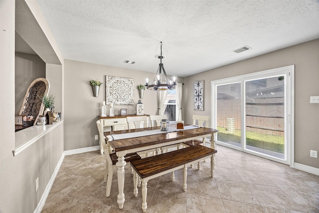 dining space with baseboards, a chandelier, visible vents, and a textured ceiling