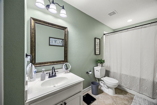 bathroom featuring toilet, visible vents, vanity, and a textured wall