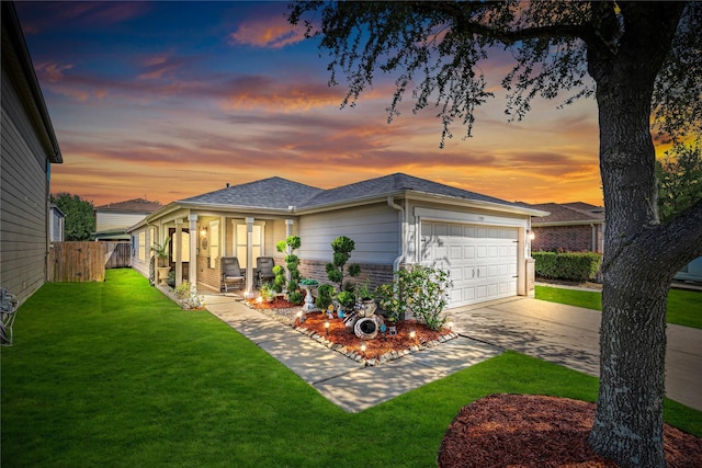 view of front of house featuring a garage, fence, a lawn, concrete driveway, and brick siding