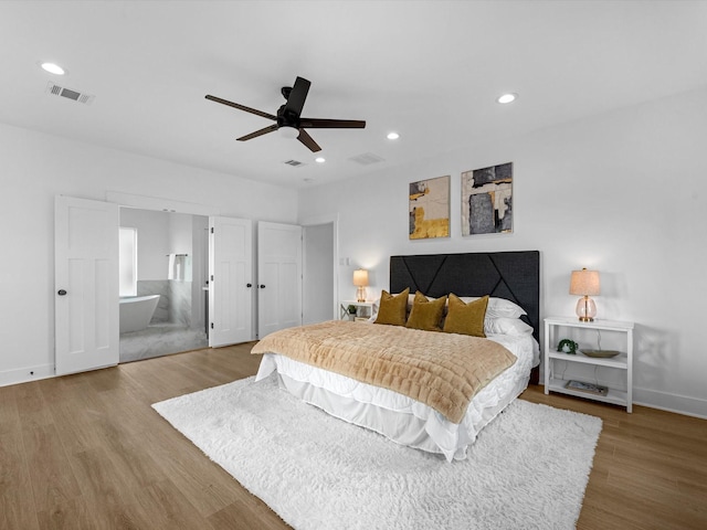bedroom with baseboards, visible vents, and wood finished floors