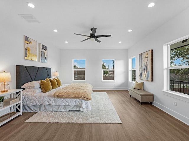 bedroom with a ceiling fan, recessed lighting, baseboards, visible vents, and wood finished floors