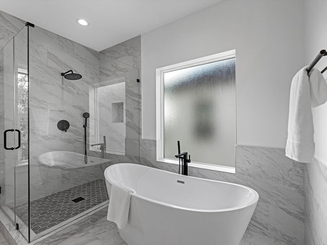 full bath featuring tile walls, a shower stall, and marble finish floor
