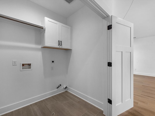 clothes washing area with cabinet space, dark wood finished floors, gas dryer hookup, baseboards, and hookup for a washing machine