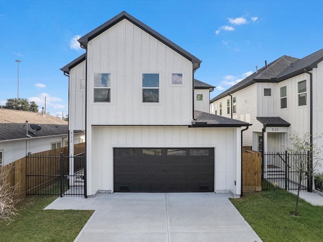 view of front of home featuring fence, concrete driveway, a garage, a front yard, and board and batten siding