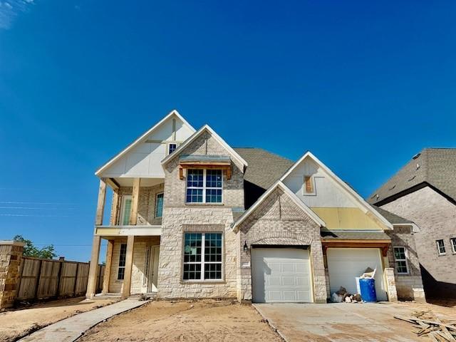 view of front of home with fence, a garage, stone siding, and driveway