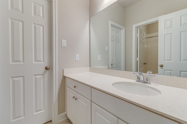 bathroom featuring walk in shower and vanity