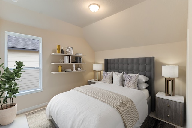 carpeted bedroom featuring baseboards and vaulted ceiling