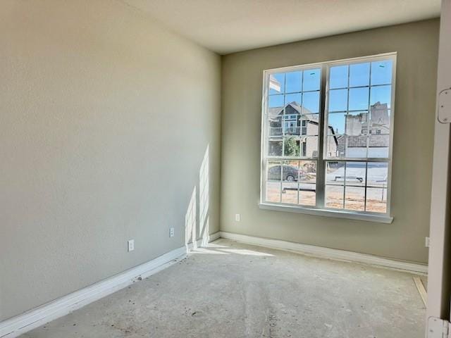 unfurnished room with baseboards