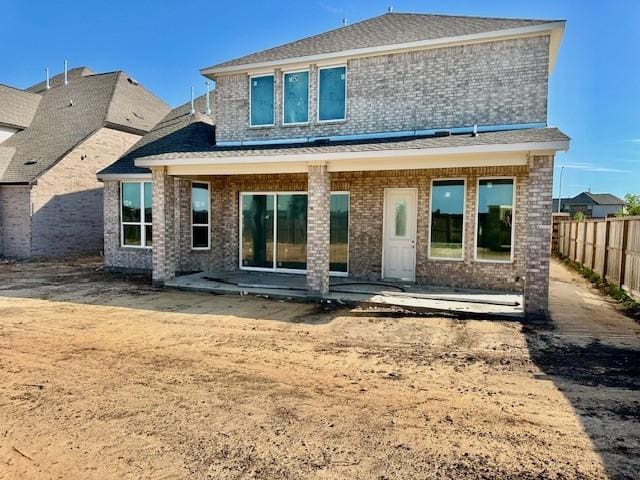 back of house featuring brick siding, fence, and a patio area