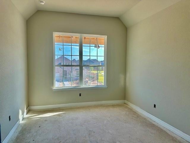 spare room with lofted ceiling, baseboards, and a healthy amount of sunlight