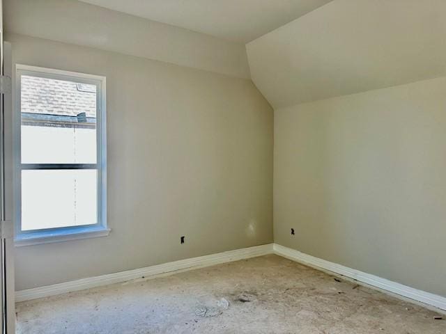 additional living space featuring baseboards and lofted ceiling