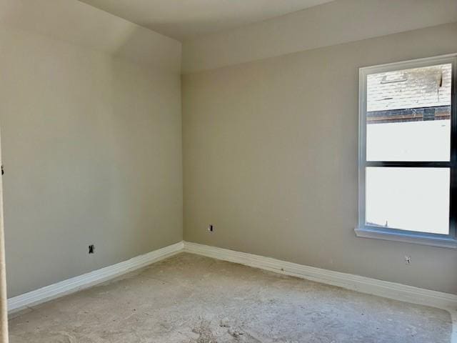 empty room featuring light colored carpet, a wealth of natural light, and baseboards
