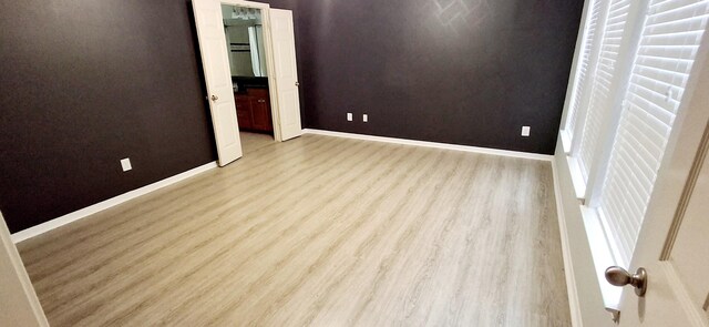 unfurnished bedroom with light wood-type flooring and baseboards