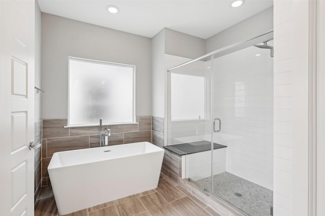 334 Yale Oaks Ln, Houston, TX 77091 - bathroom featuring tile walls, a stall shower, a soaking tub, wainscoting, and recessed lighting