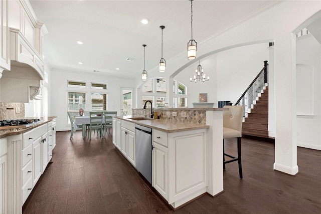18914 Trinity Star Dr, Cypress, TX 77433 - kitchen with stainless steel appliances, a sink, a breakfast bar, dark wood-type flooring, and healthy amount of natural light