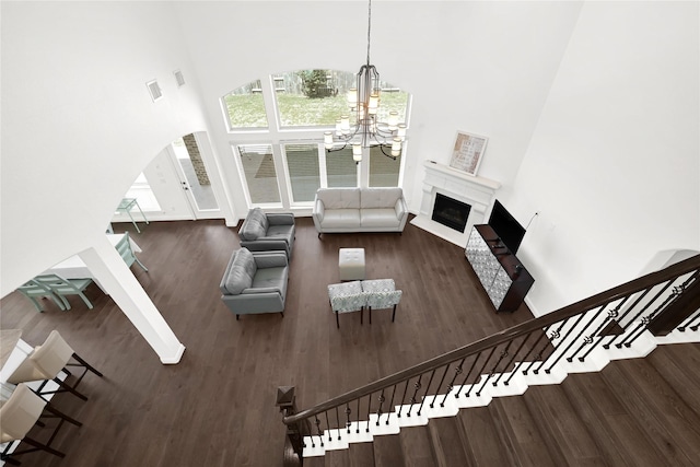 18914 Trinity Star Dr, Cypress, TX 77433 - living room featuring a towering ceiling, a chandelier, wood finished floors, stairway, and a fireplace