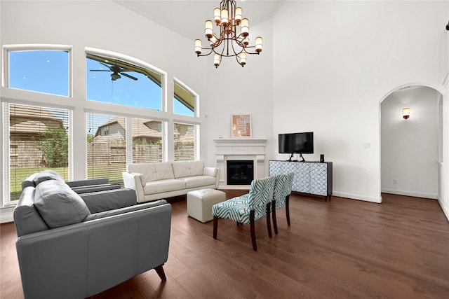 18914 Trinity Star Dr, Cypress, TX 77433 - living area featuring arched walkways, a towering ceiling, a ceiling fan, dark wood finished floors, and a glass covered fireplace