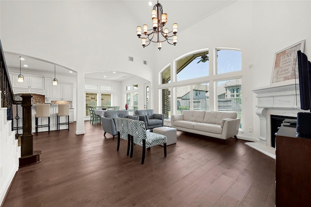 18914 Trinity Star Dr, Cypress, TX 77433 - living area featuring dark wood-type flooring, high vaulted ceiling, stairs, arched walkways, and a chandelier