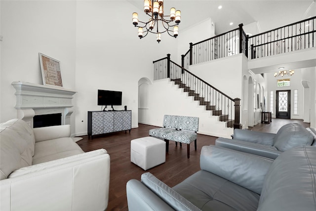18914 Trinity Star Dr, Cypress, TX 77433 - living room featuring a chandelier, arched walkways, stairway, a towering ceiling, and wood finished floors