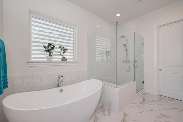 2414 W Kolbe Ln, Houston, TX 77080 - bathroom with marble look tiles, a shower stall, a freestanding bath, and recessed lighting