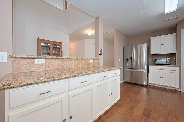 10406 Nickel Grove Dr, Houston, TX 77095 - kitchen featuring stainless steel fridge, dark wood-type flooring, backsplash, white cabinetry, and a textured ceiling