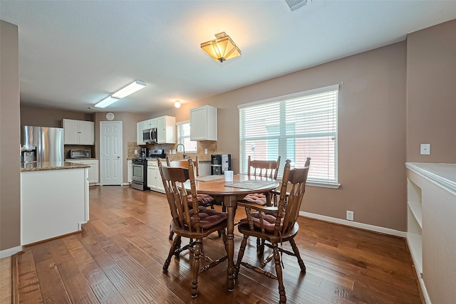 10406 Nickel Grove Dr, Houston, TX 77095 - dining space featuring dark wood-type flooring, plenty of natural light, and baseboards