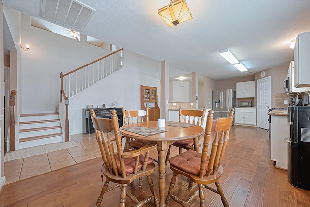 10406 Nickel Grove Dr, Houston, TX 77095 - dining room with light wood-style floors and stairway