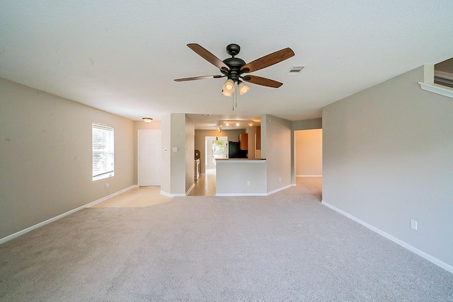 20410 Fall Foliage Dr, Humble, TX 77338 - unfurnished living room with baseboards, visible vents, ceiling fan, and light colored carpet