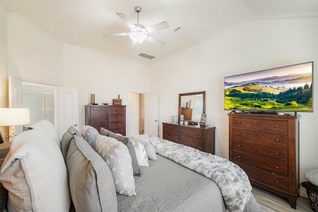 bedroom with vaulted ceiling, crown molding, light wood-type flooring, and ceiling fan
