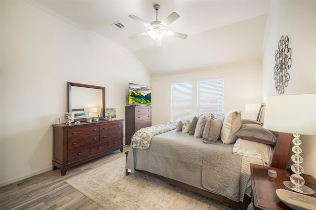 bedroom with vaulted ceiling, light wood-style flooring, crown molding, baseboards, and ceiling fan