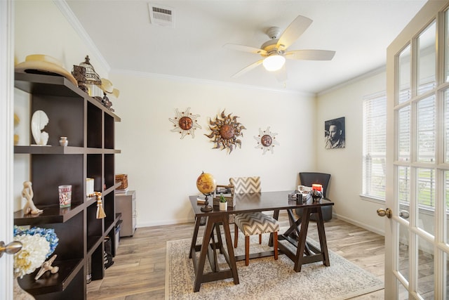 home office with healthy amount of natural light, ornamental molding, a ceiling fan, light wood-style flooring, and baseboards