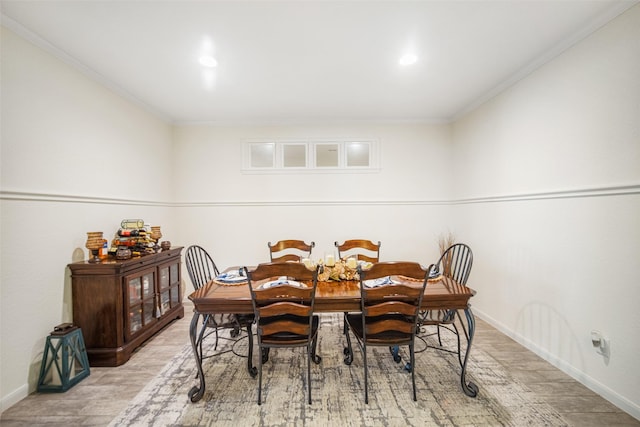 dining room with wood finished floors, crown molding, baseboards, and recessed lighting