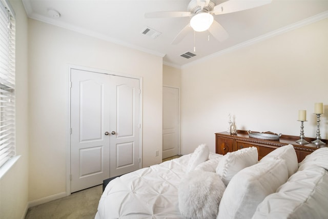 bedroom with light colored carpet, crown molding, baseboards, a closet, and ceiling fan