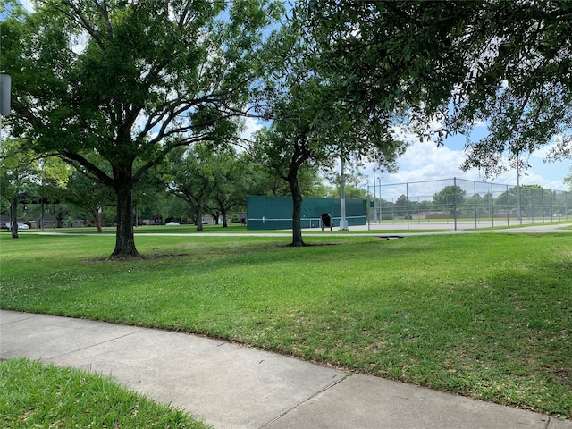 view of home's community with a yard and fence