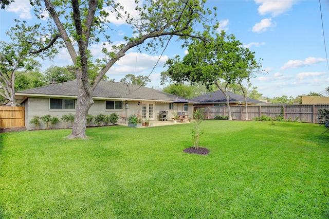 rear view of property featuring french doors, a lawn, and a fenced backyard