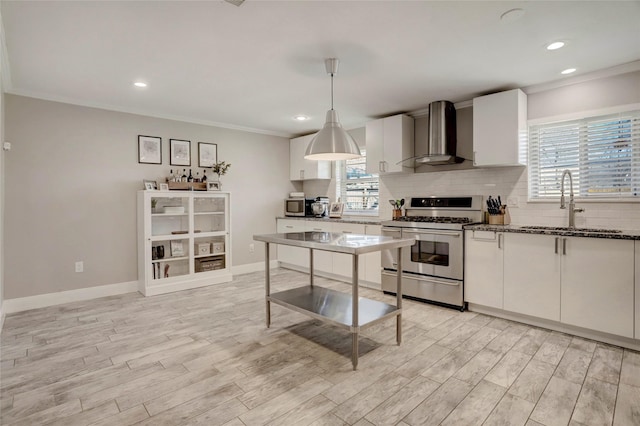 11915 Atwell Dr, Houston, TX 77035 - kitchen with appliances with stainless steel finishes, wall chimney exhaust hood, a sink, light wood finished floors, and tasteful backsplash