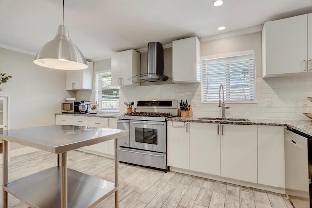 kitchen featuring stone counters, a sink, wall chimney range hood, tasteful backsplash, and appliances with stainless steel finishes